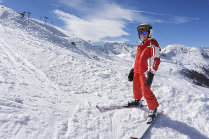 Smiling boy in ski suit on the snow
